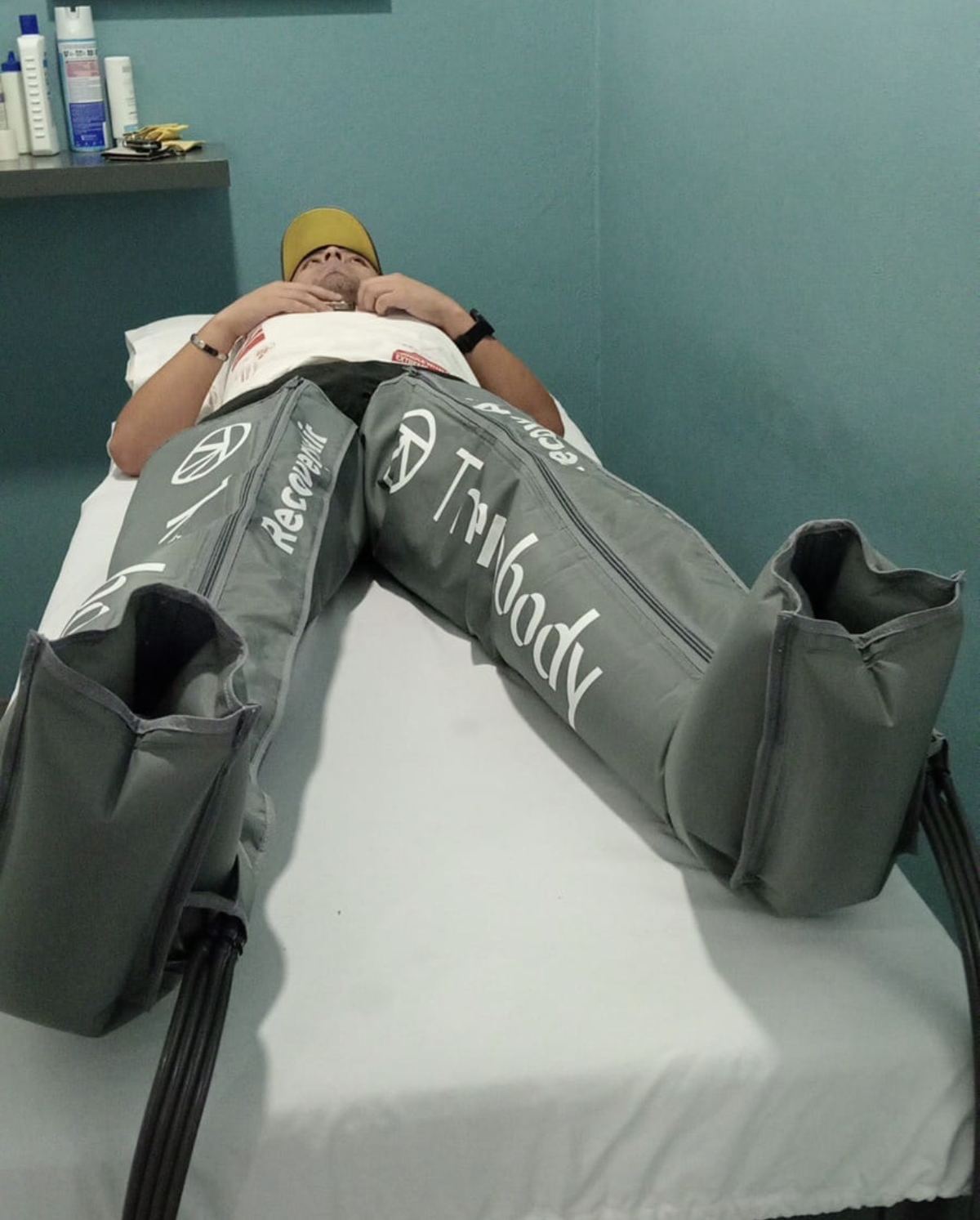 Paciente recostado con las botas de presoterapia puestas, en cabina de Fisiomove